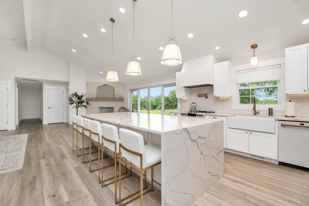 a-large-kitchen-with-a-marble-island-and-white-cabinets-o-updnnssda