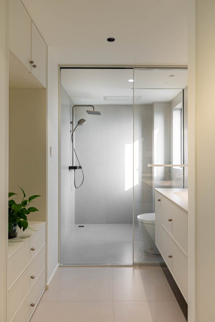 Bright and elegant modern bathroom with glass shower and sleek cabinetry.