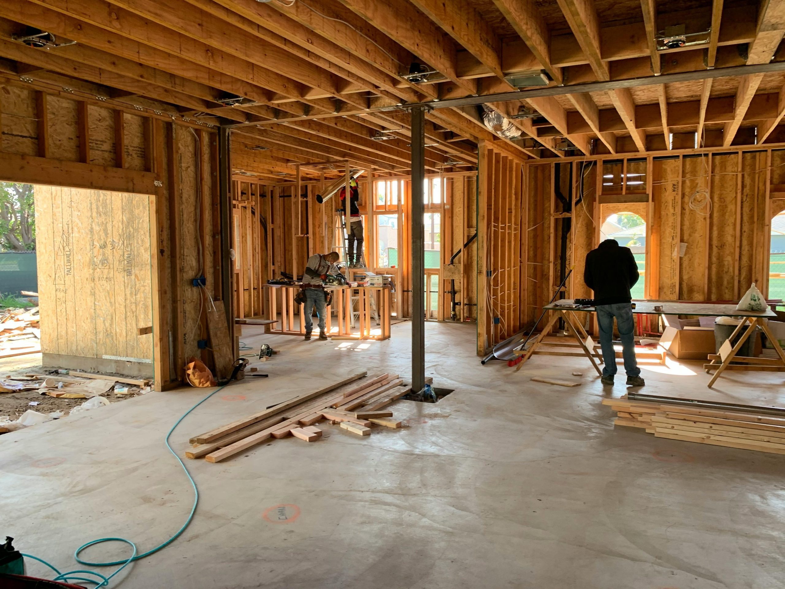 What to Expect When Building a Custom Home in Volusia County, Florida Workers constructing a house framework, showcasing interior carpentry and building process.